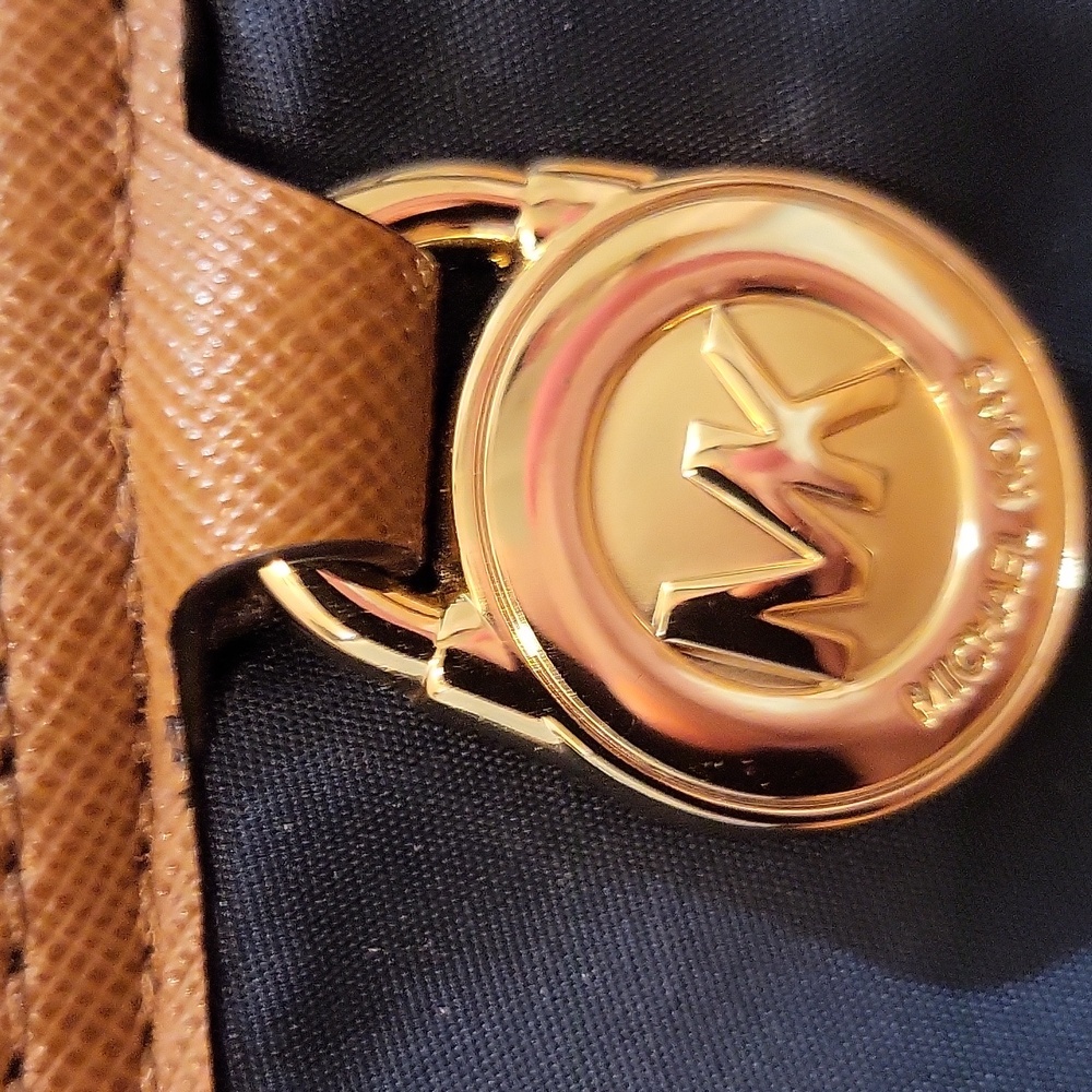 Mk purse easy to clean.its almost like vinyl and it has leather shoulder handle